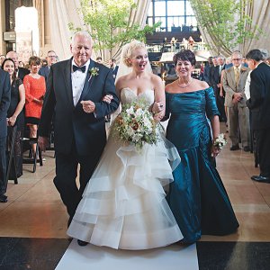 bride walking down the aisle with parents